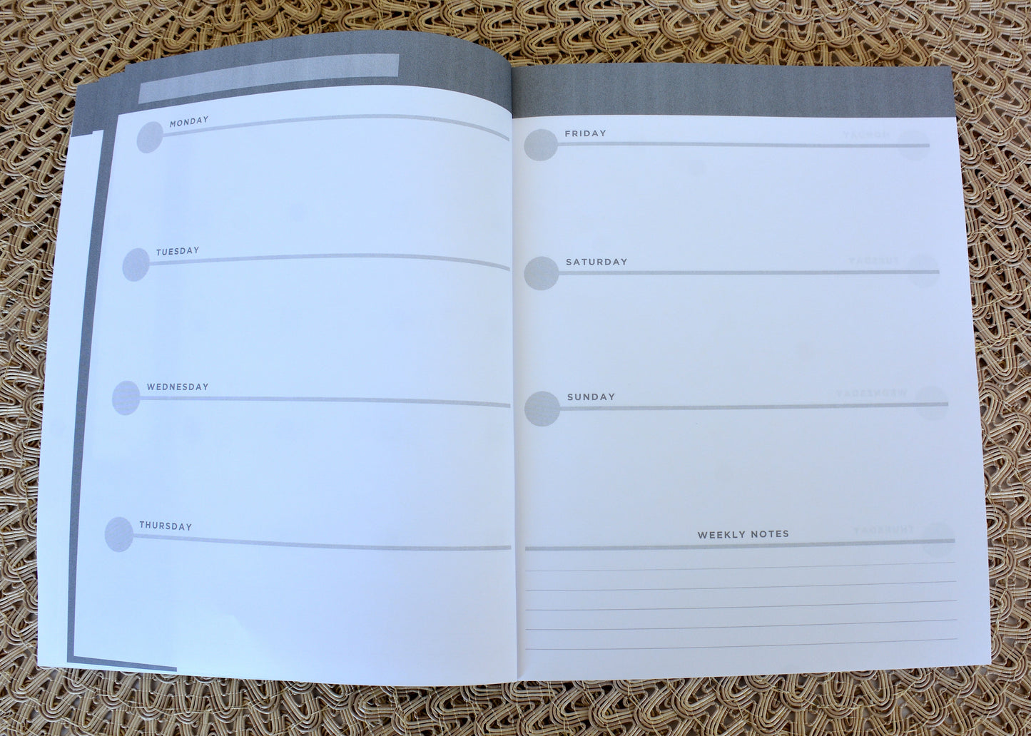 Open planner with weekly schedule on a textured surface