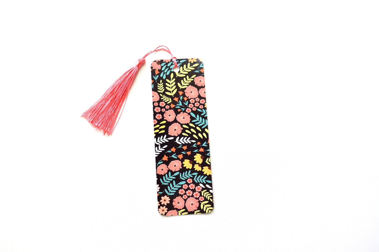 Colorful Floral and leaves pattern bookmark with a pink tassel on a white background