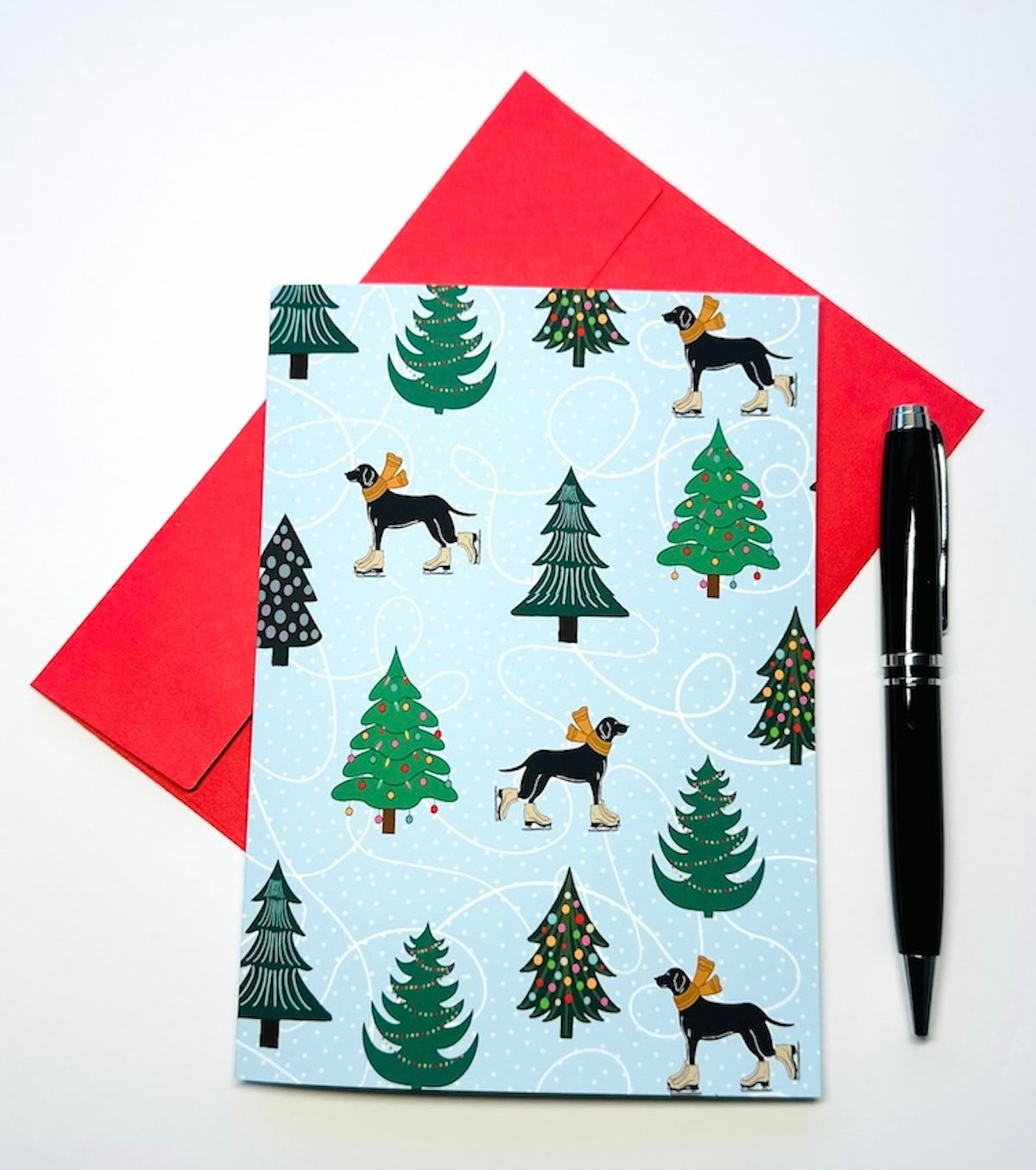 Black Dog Ice Skating Pattern with Snow Covered Trees wearing Scarf Christmas Holiday Greeting Card with Red Envelope