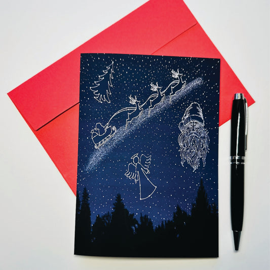 Holiday Greeting card with celestial sky showing Santa Claus sleigh, reindeer, angel, and stars on a blue background with a red envelope and pen.