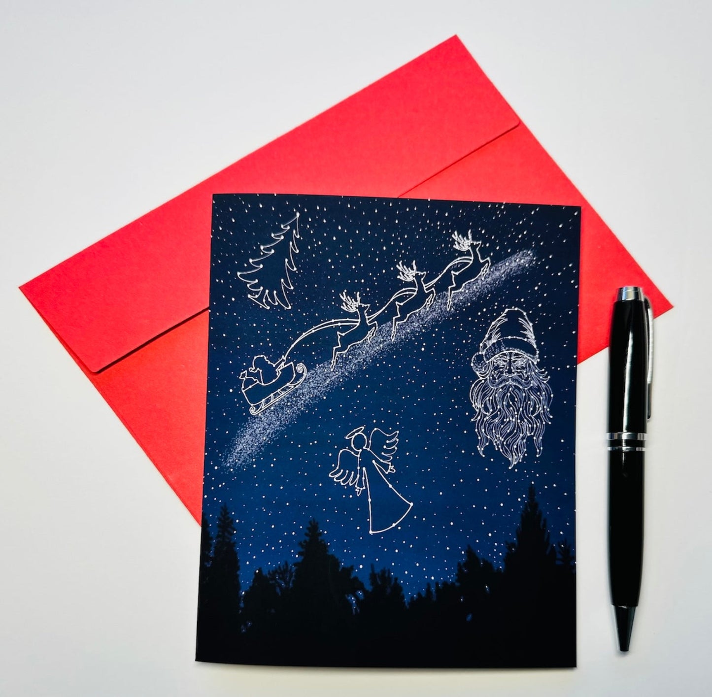 Celestial Night Sky with Santa Face, an Angel, Santa's Sleigh with Reindeer, and Christmas Tree in stars, Christmas Holiday Greeting Card with Red Envelope