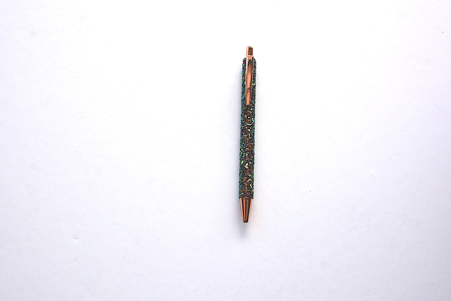 Glitter pen in dark green color with sequined sparkly texture with rose gold accents on white background
