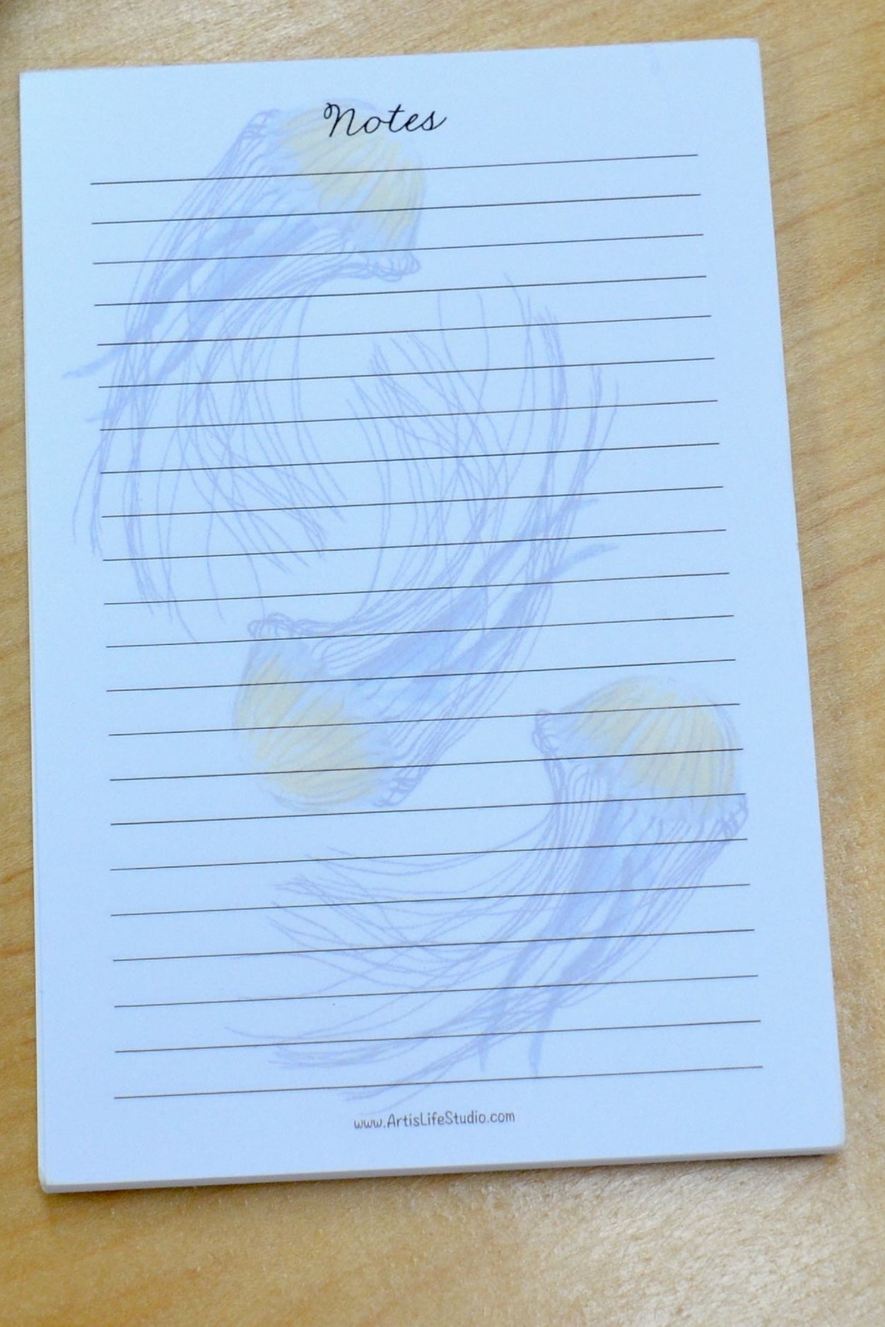 Jellyfish Notepad with lined pages on a wooden surface