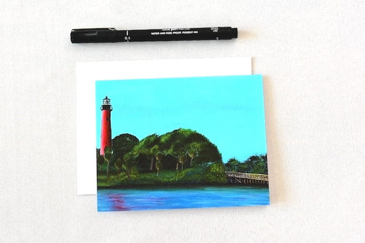 Painting of the Jupiter Lighthouse on a card with white envelope and pen 