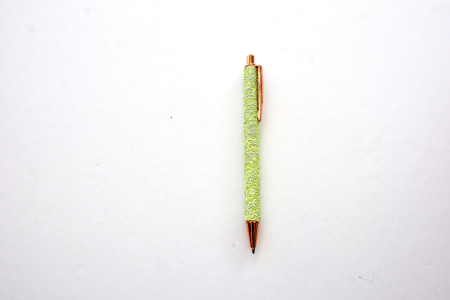 Glitter pen in lime green color with sequined sparkly texture with rose gold accents on white background