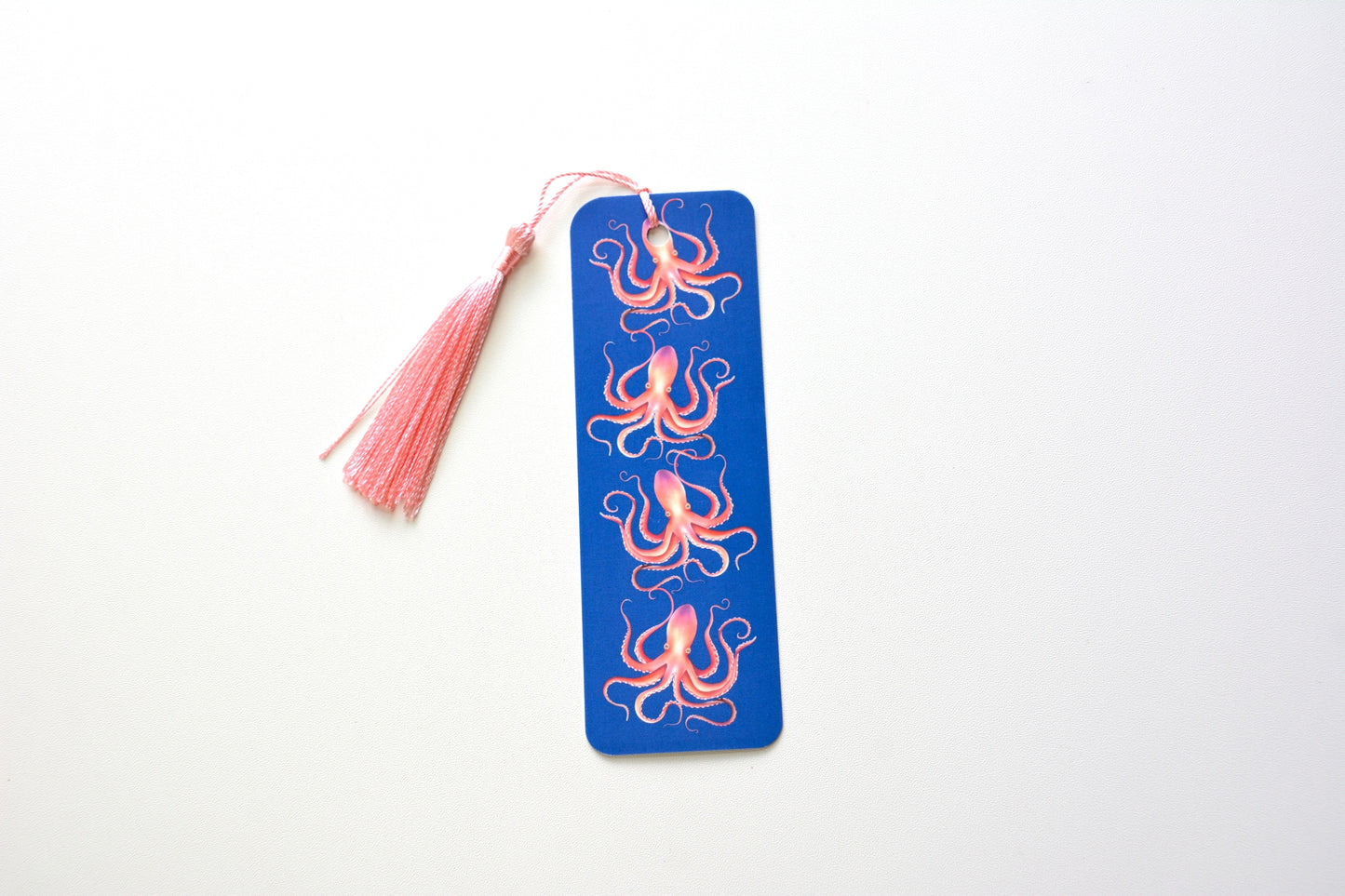 Blue bookmark with pink, orange and purple octopus design pattern and tassel on a white background