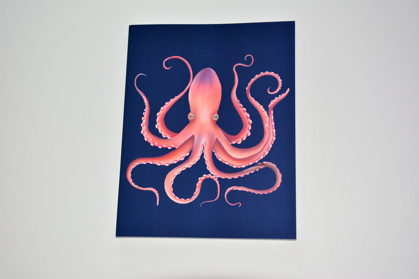 Notebook  with pink, orange and purple octopus design on a blue background
