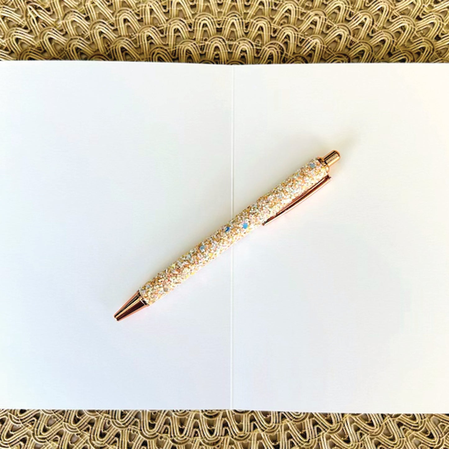 Inside of greeting card showing blank inside with glitter pen on textured background