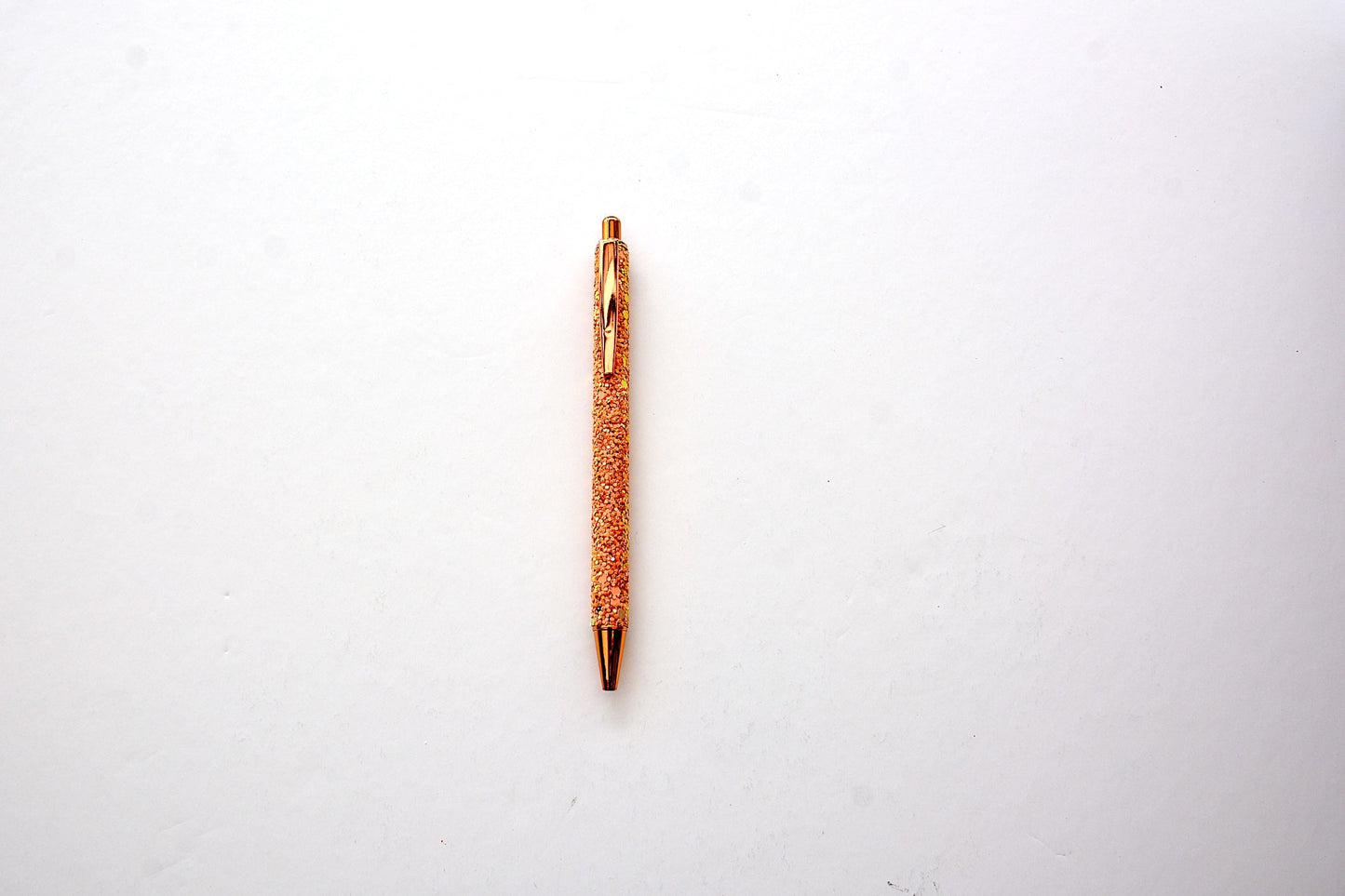Glitter pen in rose gold color with sequined sparkly texture with rose gold accents on white background
