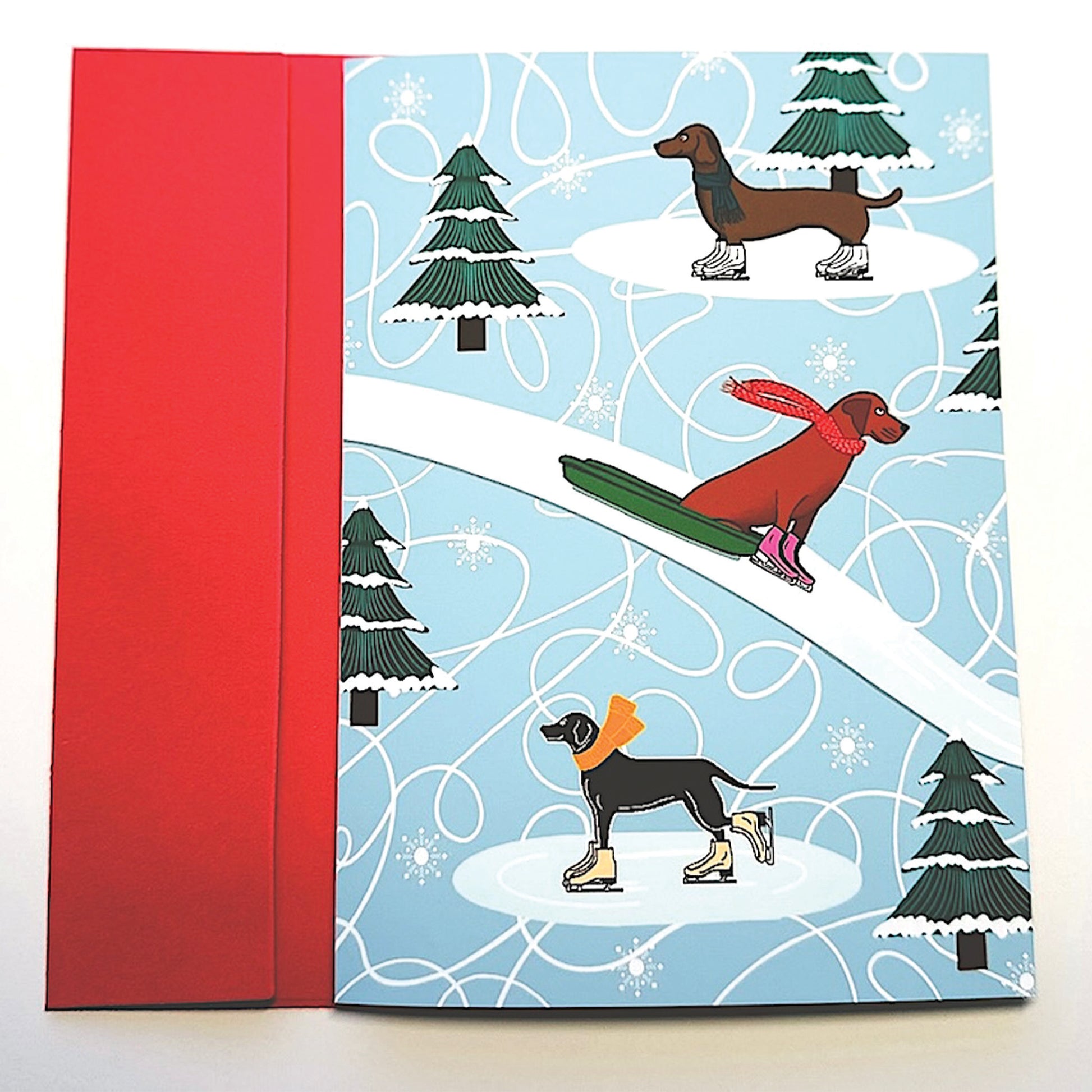 Holiday Card with dogs ice skating and on sled with scarves and trees with snow with red envelope