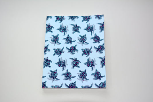 Notebook with artist designed turtle pattern on light blue background