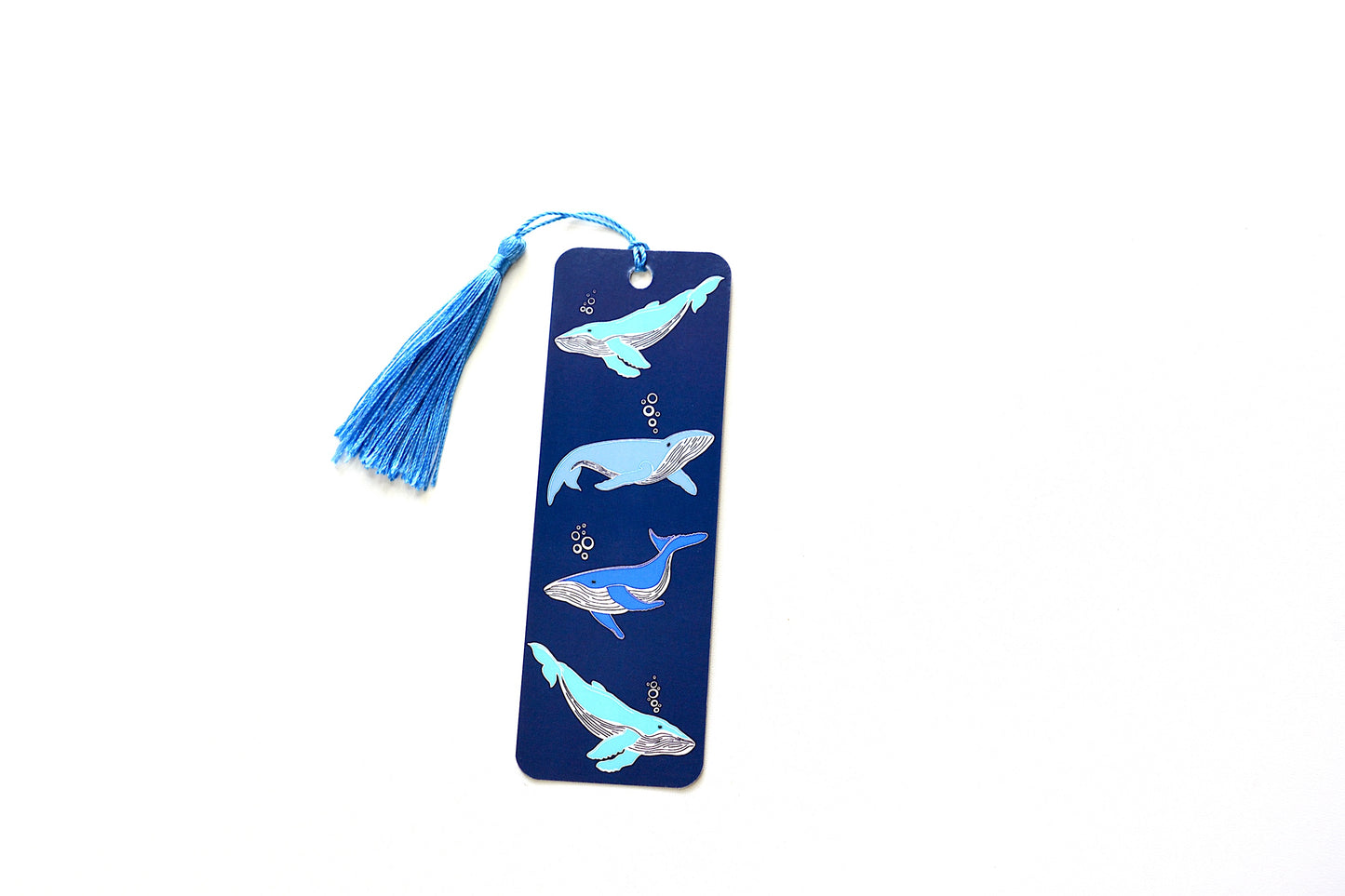 Bookmark with whale pattern and a  blue tassel on a white background