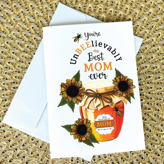 Mothers Day Greeting card with honey jar and sunflowers and bees and text "You're unbeelievably the best mom ever' on a textured surface